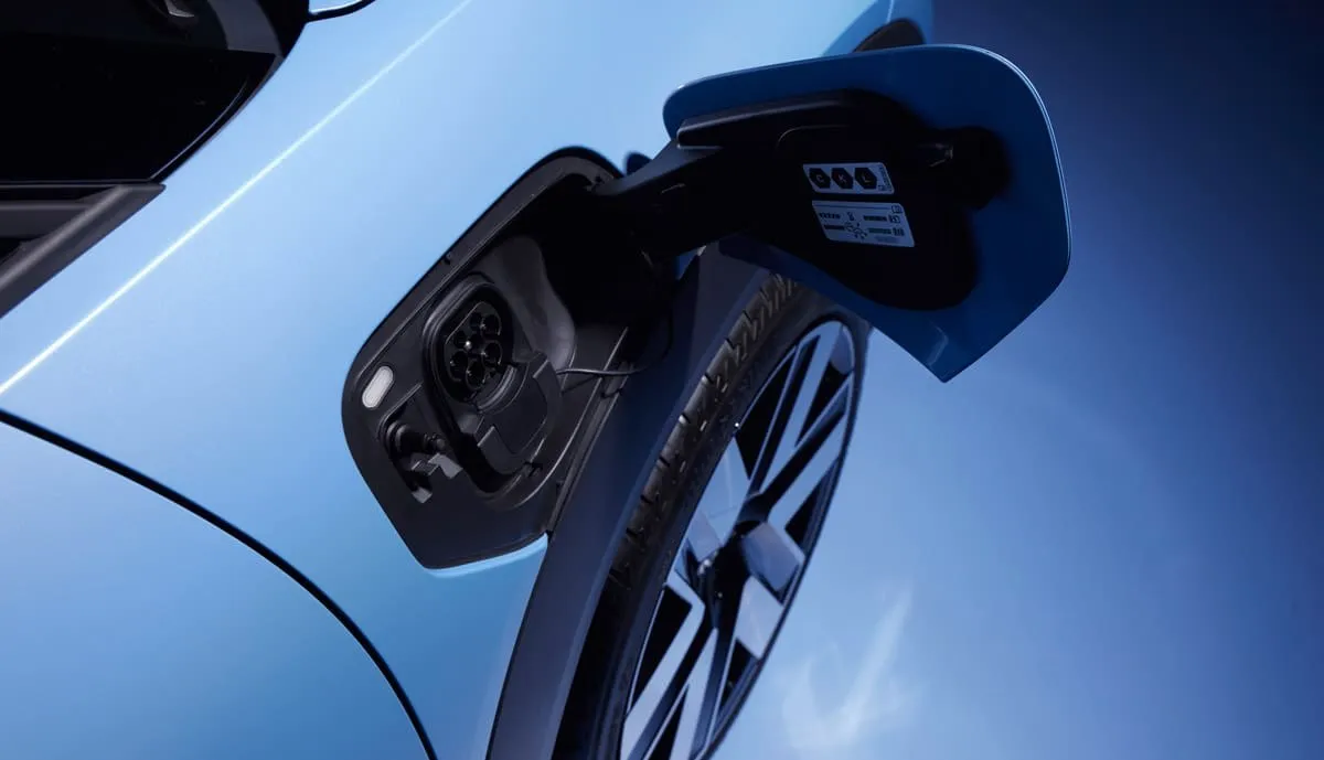 Ladekabel steckt im Anschluss eines blauen VW-Elektroautos, Symbolbild