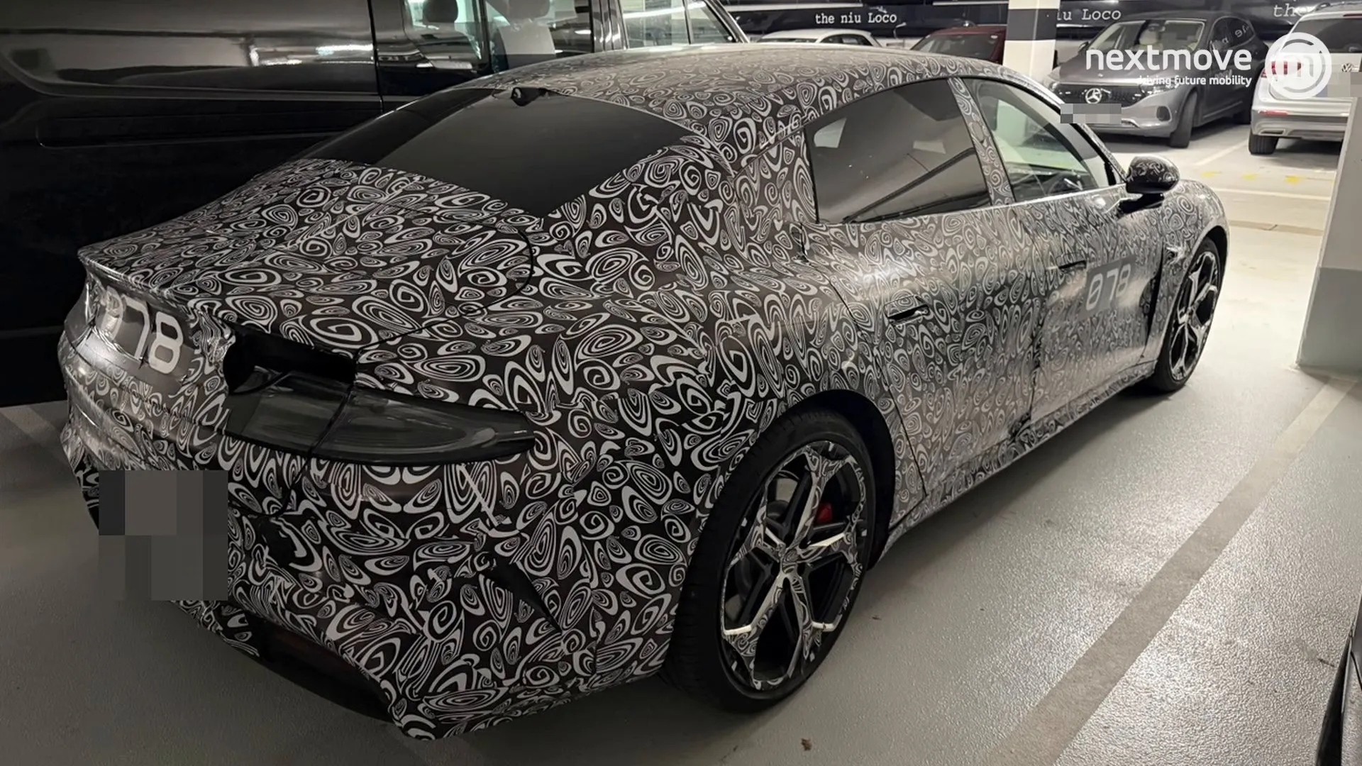 Getarnte Limousine, wahrscheinlich ein Xiaomi SU7, in einer Tiefgarage in München
