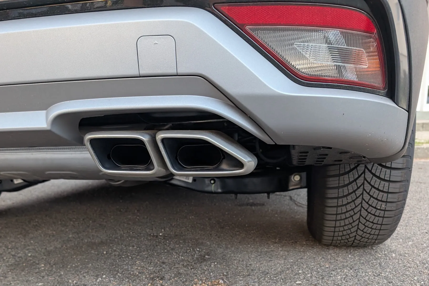 Doppelendrohr am Heck eines Autos mit Verbrennungsmotor, Symbolbild